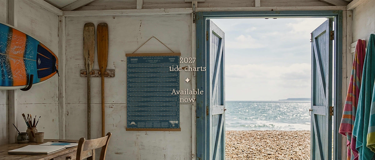 Beach hut with a 2027 tide chart on the wall and the doors open to the sea: 2027 tide charts available now